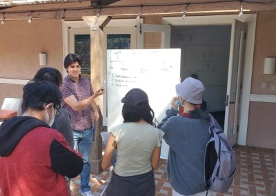 Student presenting to a group in front of a whiteboard outdoors