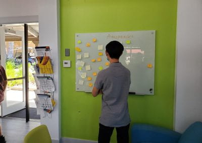 Student looking at whiteboard with sticky notes attached