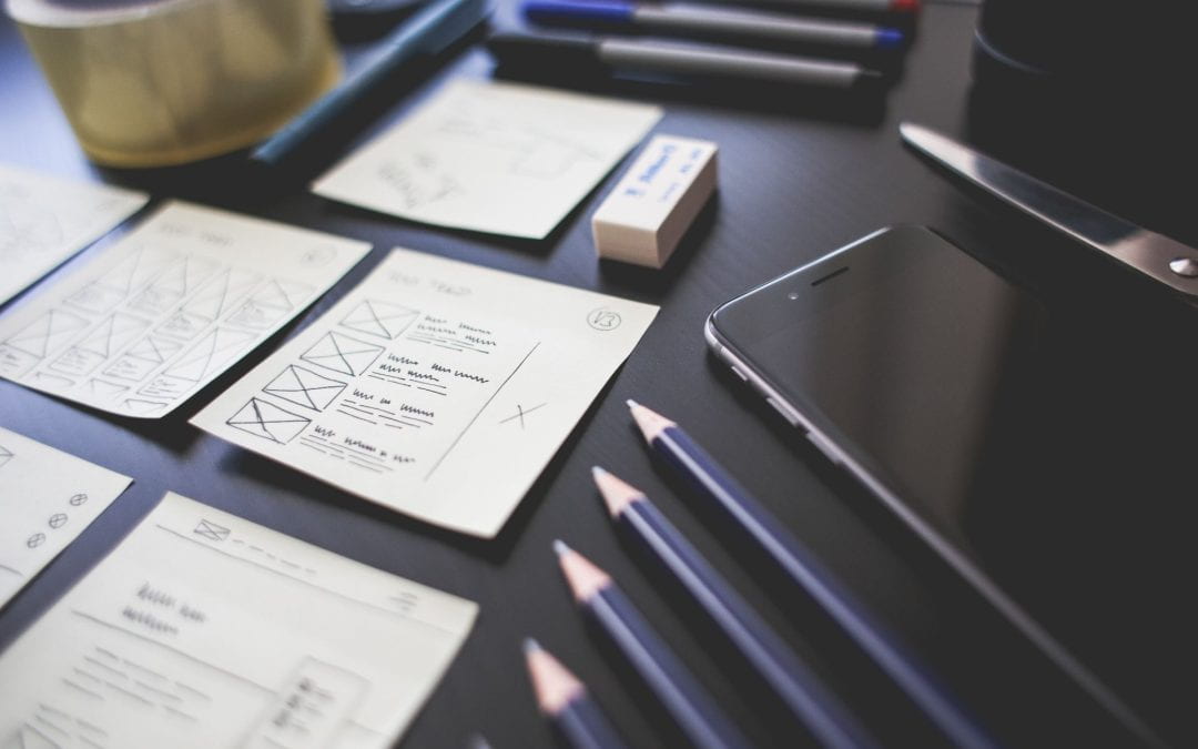 app wireframes with black iphone and black pencils