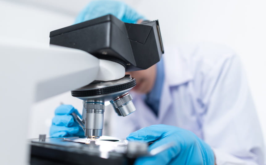 close-up of a researcher looking through a microscope
